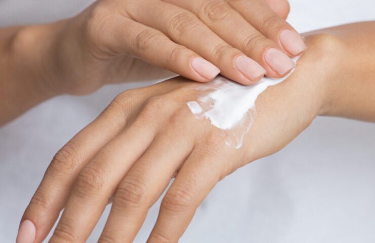 Skin Nutrition. Woman Spreading Nourishing Cream On Hand